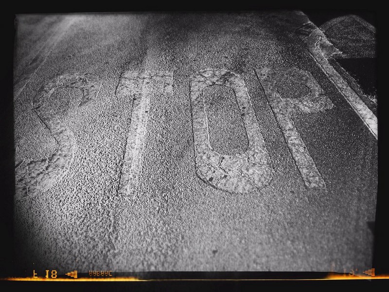 STOP written on pavement in black and white.