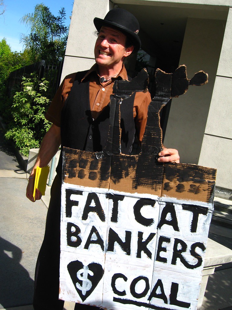 Man with sign that reads “Fat Cat Bankers Love Coal”